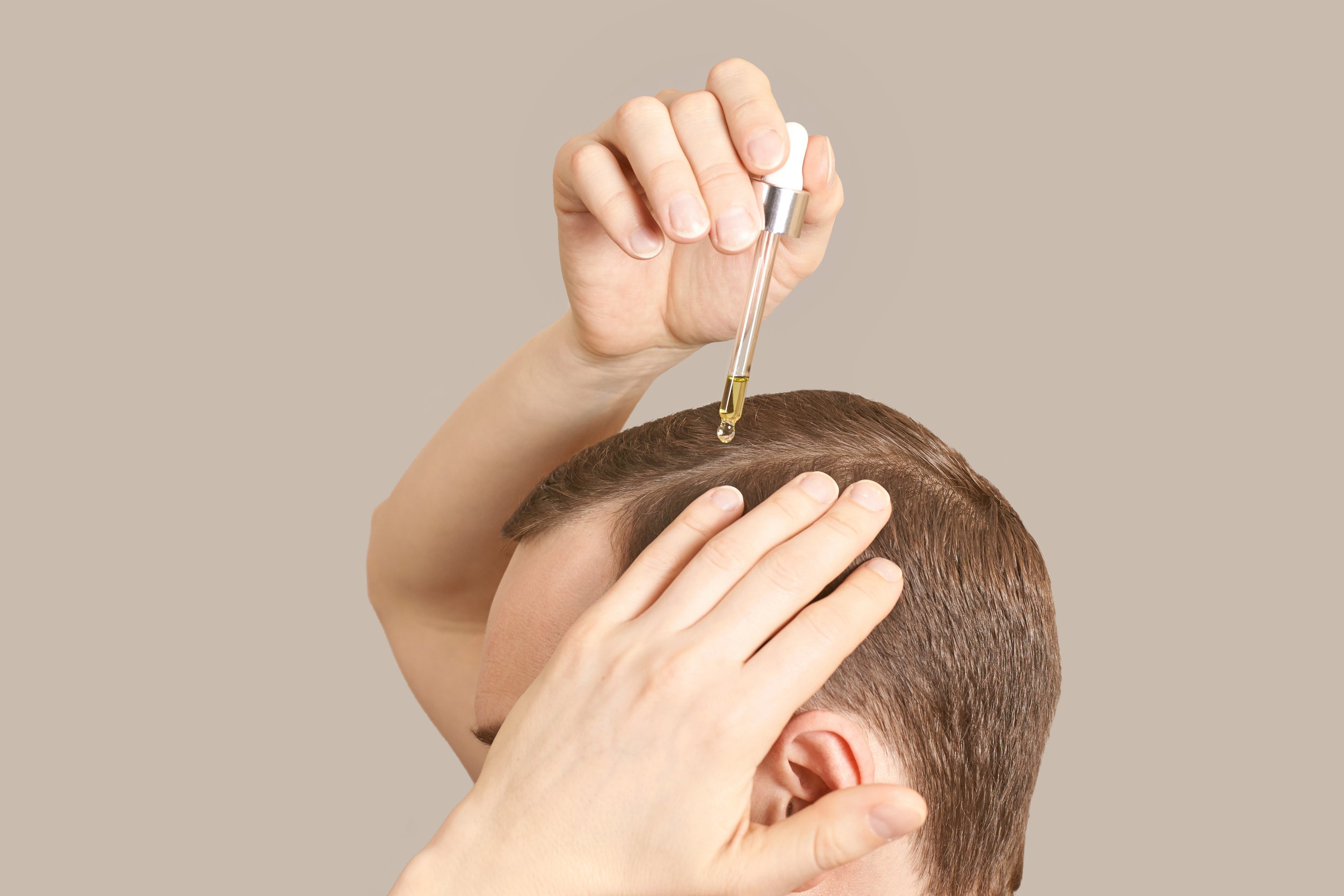 Man Applying Serum on His Scalp  